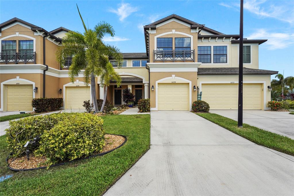 A kitchen with stainless steel appliances, light-colored cabinets, granite countertops, and a wood-paneled island — 5274 78TH ST CIRCLE E, BRADENTON, FL