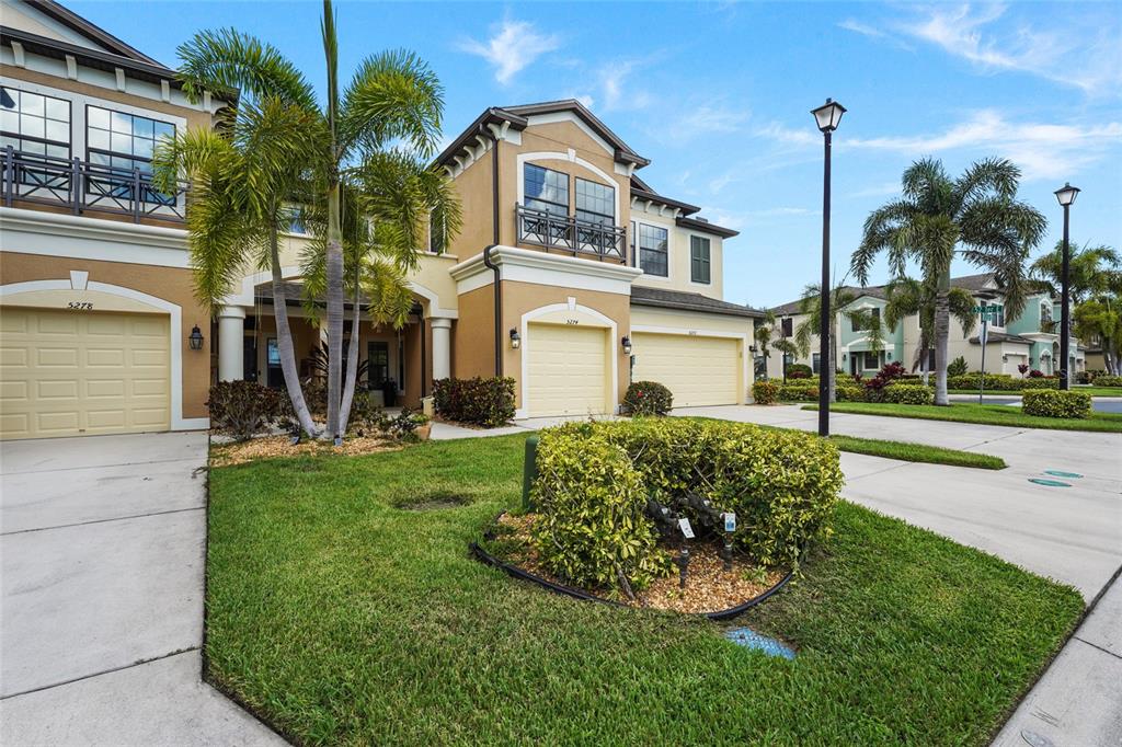 A kitchen features light-colored cabinetry, granite countertops, stainless steel appliances, and open industrial-style shelving — 5274 78TH ST CIRCLE E, BRADENTON, FL