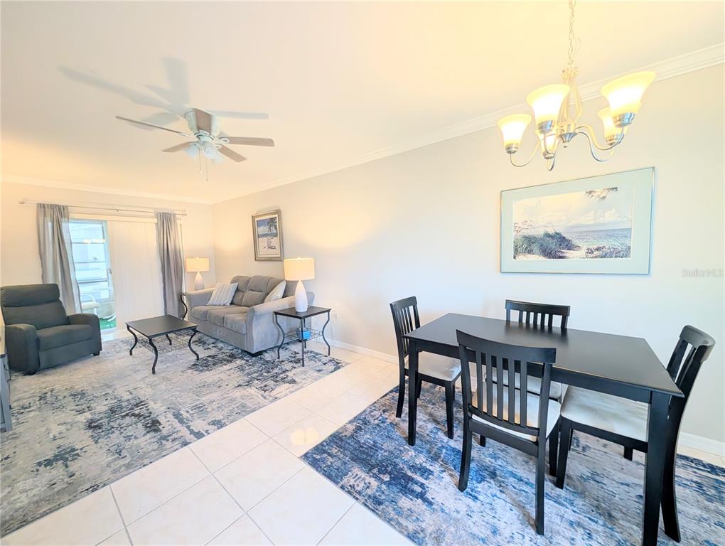 A living and dining room area features tile flooring, area rugs, and a ceiling fan — 1839 SUNNY DRIVE UNIT E36, BRADENTON, FL
