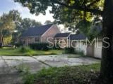 A single-story brick house with a large concrete driveway and a detached garage — 423 SW ALDERENE PARK WAY, MADISON, FL