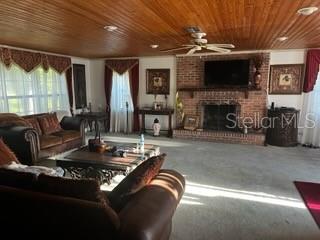 A living room features a brick fireplace, wood-paneled ceiling, and a ceiling fan — 423 SW ALDERENE PARK WAY, MADISON, FL