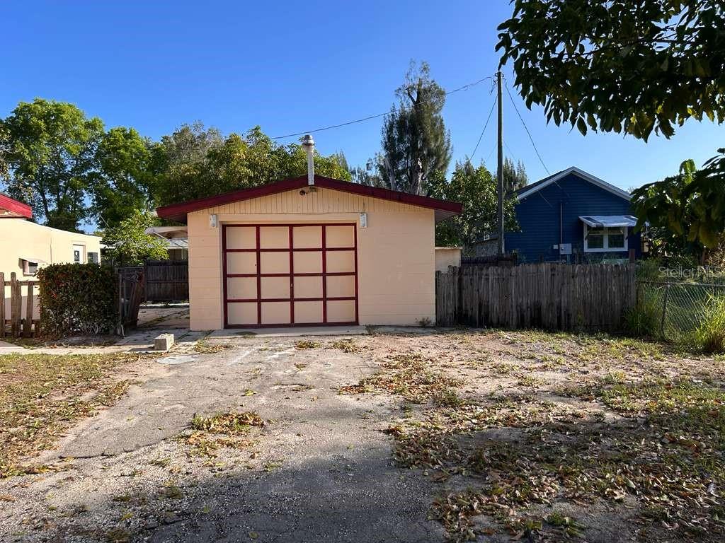 A detached, single-car garage with a light-colored exterior and a red-trimmed garage door — 340 SANTA BARBARA STREET, NORTH FORT MYERS, FL
