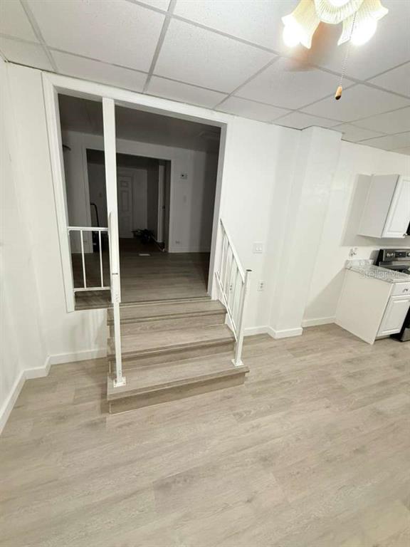 A room with light wood-look flooring features a short staircase leading to an adjacent area — 340 SANTA BARBARA STREET, NORTH FORT MYERS, FL