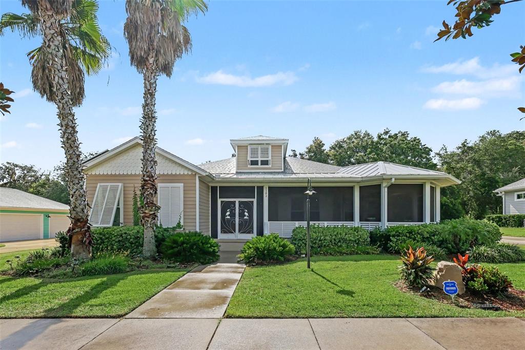 A single-story house with a screened porch, palm trees, and a concrete walkway — 1182 FIESTA KEY CIRCLE, LADY LAKE, FL