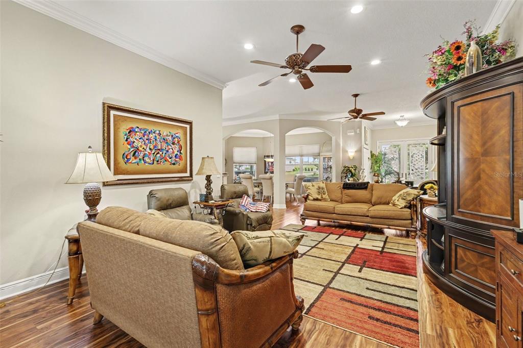 A living room features wood flooring, a patterned area rug, and traditional furniture — 1182 FIESTA KEY CIRCLE, LADY LAKE, FL