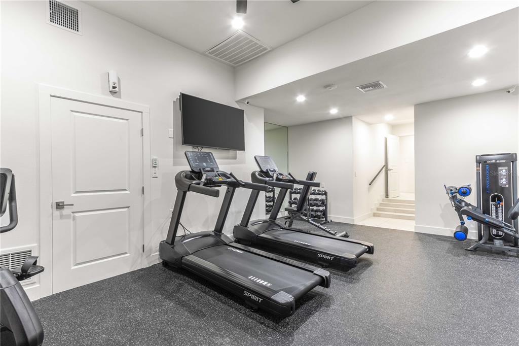 A home gym features two treadmills, a weight rack, and a multi-station strength machine — 1380 GULF BOULEVARD UNIT 805, CLEARWATER, FL