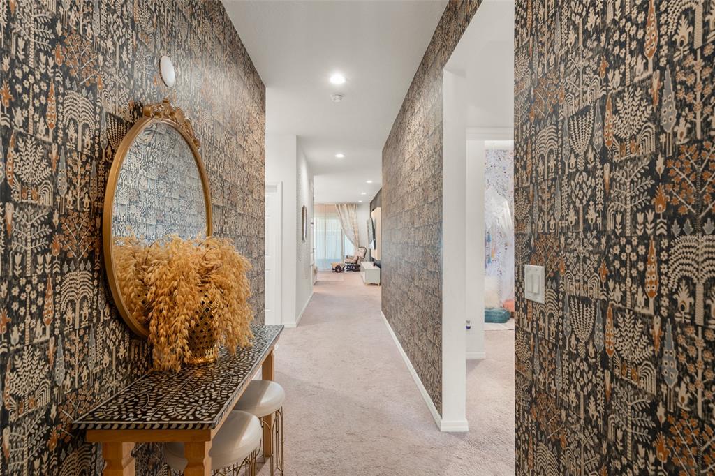A narrow entryway features patterned wallpaper, a console table with a mirror, and a door — 1195 CRANE TALON WAY, SANFORD, FL