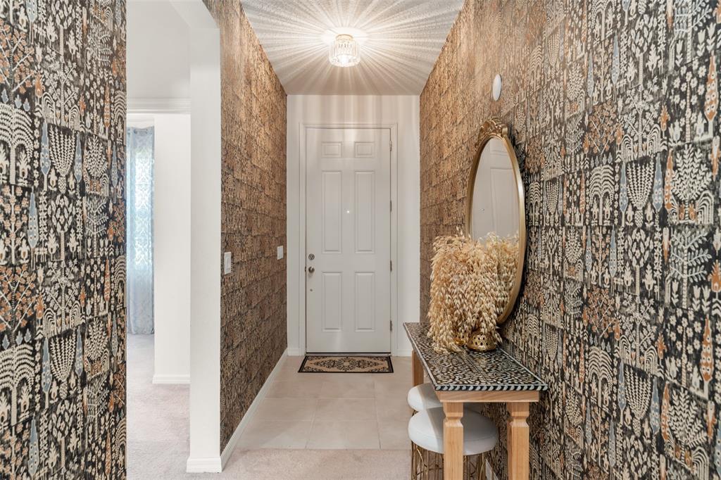 A hallway features a bathroom on the left, a bedroom ahead, and a patterned accent wall — 1195 CRANE TALON WAY, SANFORD, FL