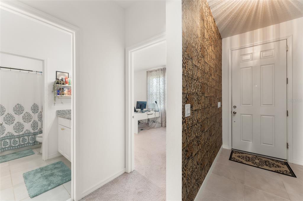 A home office features a white desk, beige carpet, and floor-to-ceiling curtains over a window — 1195 CRANE TALON WAY, SANFORD, FL