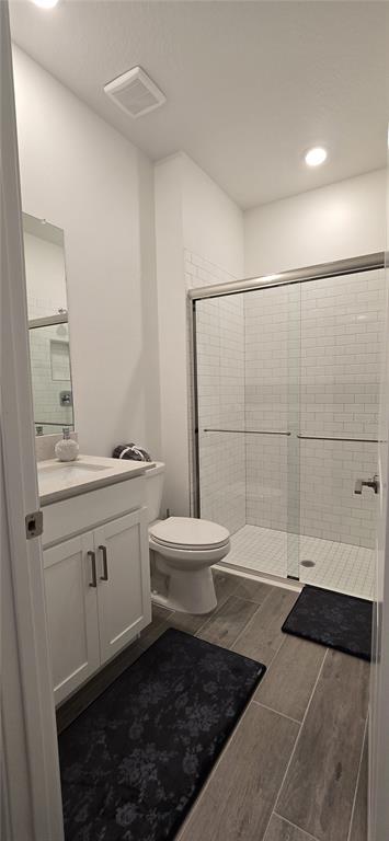 A bathroom with a white vanity, a toilet, and a glass-enclosed walk-in subway tile shower — 7518 117TH LANE E, PALMETTO, FL