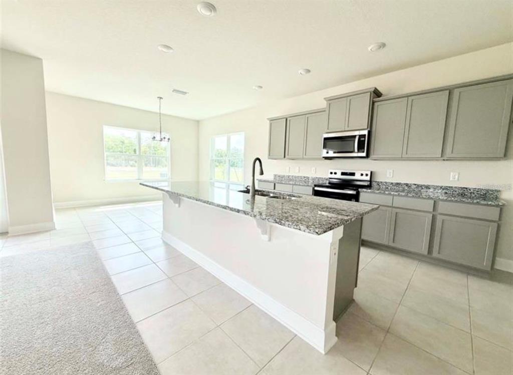 A bathroom features a white vanity with granite countertops, a soaking tub, and a shower — 7727 BENT TREE LOOP, ST CLOUD, FL