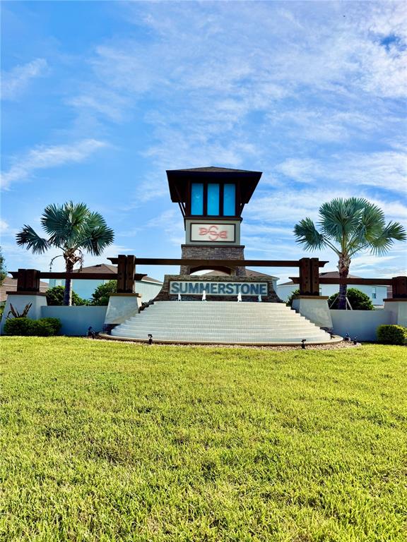 The exterior of the Summerstone community entrance features a tiered fountain and a tall monument sign — 34110 JASPER STONE DRIVE, WESLEY CHAPEL, FL