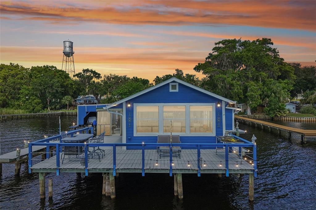 An aerial view of a blue house on stilts surrounded by a large body of water — 21 S LAKE STREET, CRESCENT CITY, FL