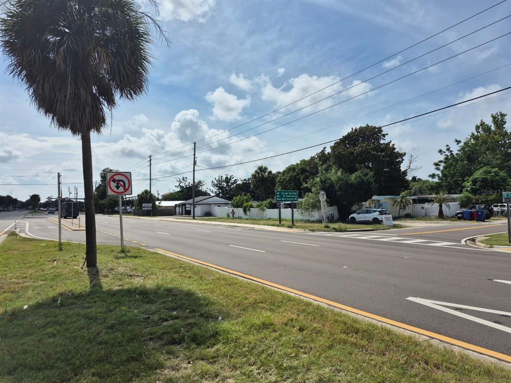 A dark SUV drives on a multi-lane road past an Amazon delivery truck and signage — 4007 FLAMINGO DRIVE, NEW PORT RICHEY, FL