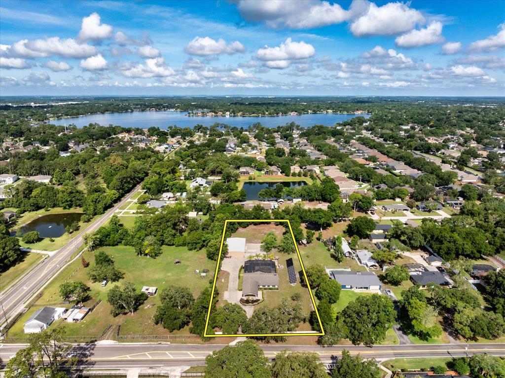 An open black metal gate leads to a paved driveway and a single-story house — 524 EDEN PARK, ALTAMONTE SPRINGS, FL