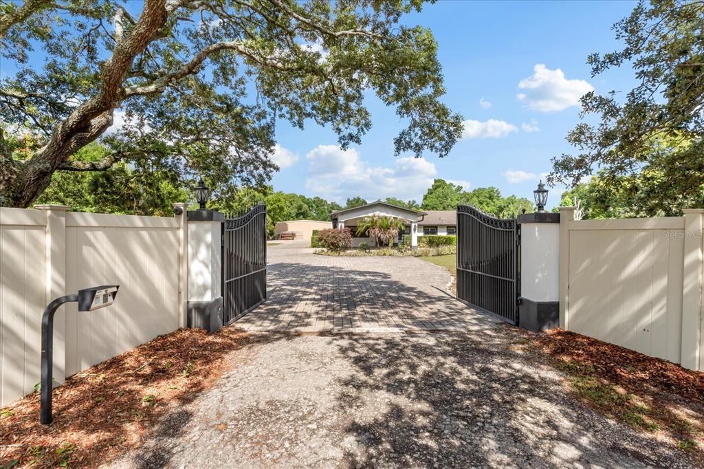 A kitchen features dark wood cabinets, granite countertops, a center island, and stainless steel appliances — 524 EDEN PARK, ALTAMONTE SPRINGS, FL