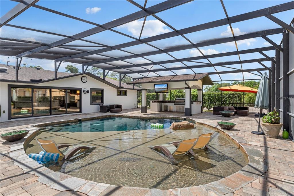An outdoor kitchen with a stainless steel grill, granite countertops, and a ceiling fan — 524 EDEN PARK, ALTAMONTE SPRINGS, FL