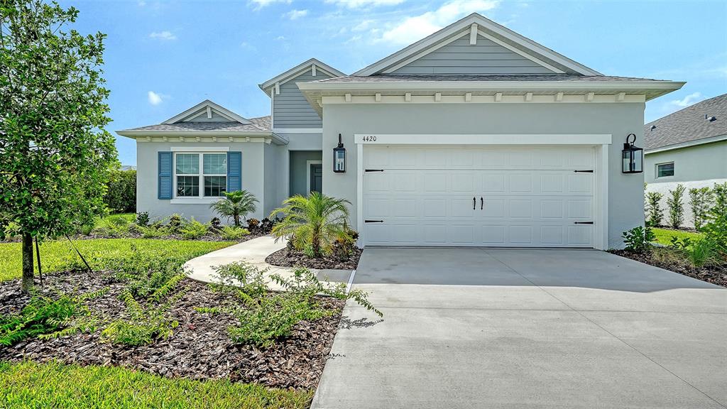 A single-story house with a white garage, gray siding, and blue shutters under a blue sky — 4420 WATER LANDING WAY, PARRISH, FL