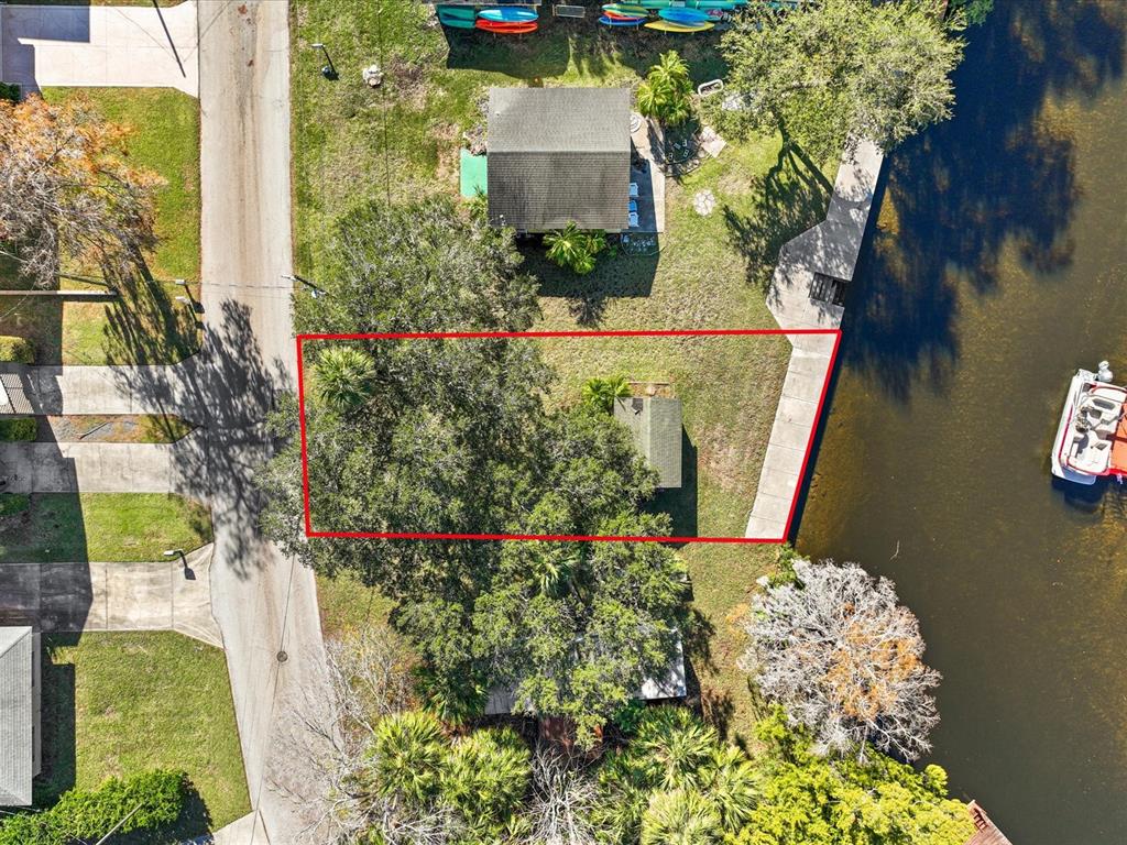 An aerial view shows a residential lot outlined in red beside a canal — 7259 TROPICAL DRIVE, WEEKI WACHEE, FL