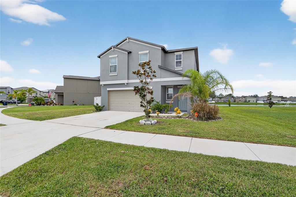 A two-story gray house with a two-car garage sits on a grassy lot — 12788 MAPLE BONSAI DRIVE, RIVERVIEW, FL