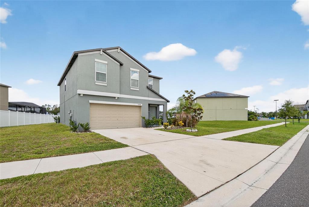 A two-story house with a light green exterior, a two-car garage, and a concrete driveway — 12788 MAPLE BONSAI DRIVE, RIVERVIEW, FL