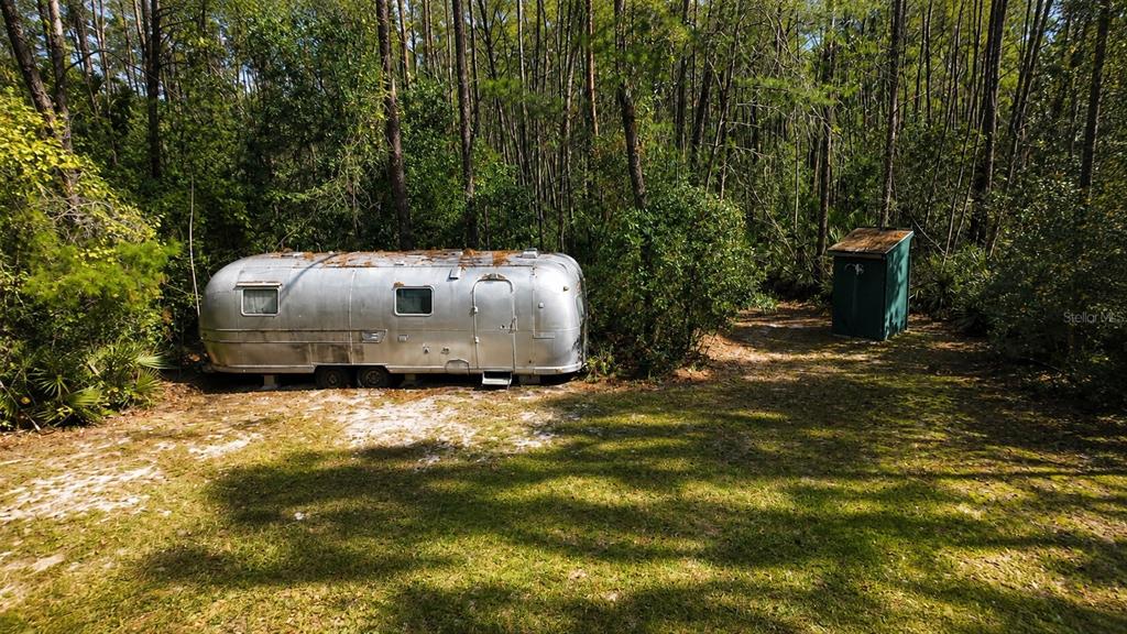 An aerial view shows a wooded lot with a silver trailer, a van, and a structure — 0 5TH STREET, ALTOONA, FL