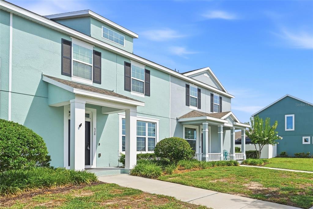 A light blue two-story townhouse with a covered front porch and a concrete walkway — 528 RAINBOW SPRINGS LOOP, GROVELAND, FL