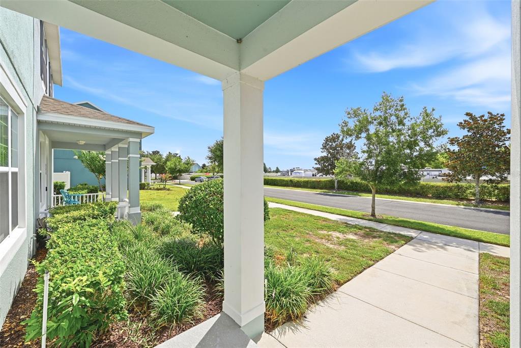 A view from a covered front porch looking out toward a street and landscaping — 528 RAINBOW SPRINGS LOOP, GROVELAND, FL