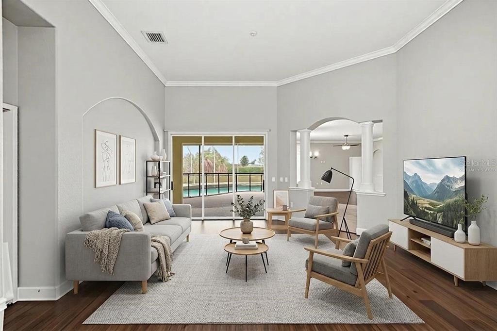 A living room with gray furniture, a nested coffee table, and a view of a pool — 200 LAKE ARIETTA COURT, AUBURNDALE, FL