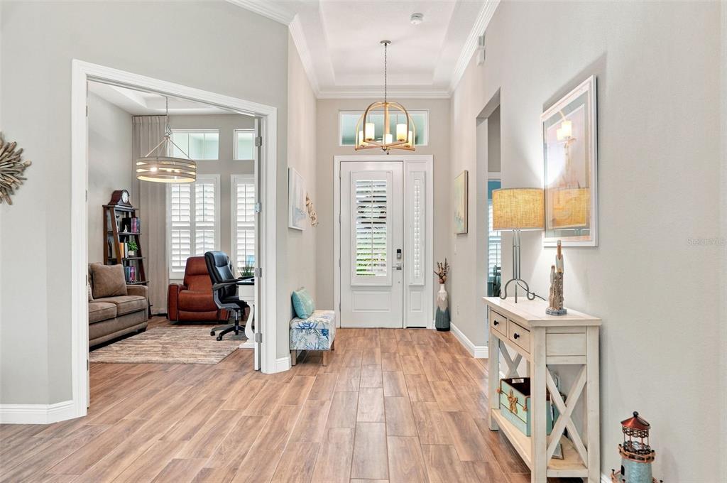 A light blue house with a three-car garage and a paved driveway under a blue sky — 4093 EPIC COVE, LAND O LAKES, FL