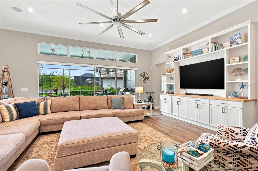 A bright entryway features wood-look flooring, a white front door, and an adjacent home office — 4093 EPIC COVE, LAND O LAKES, FL