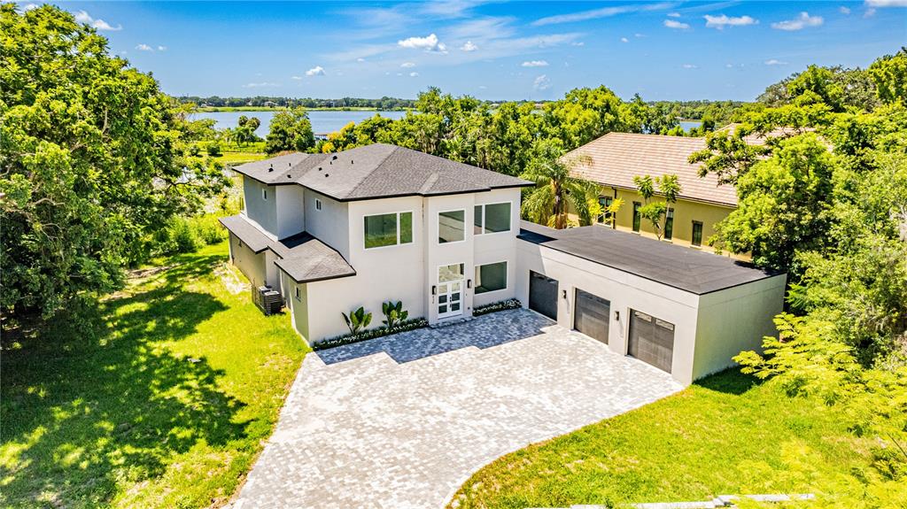 An aerial view shows a modern two-story house with a three-car garage and paved driveway — 436 E 7TH AVENUE, WINDERMERE, FL
