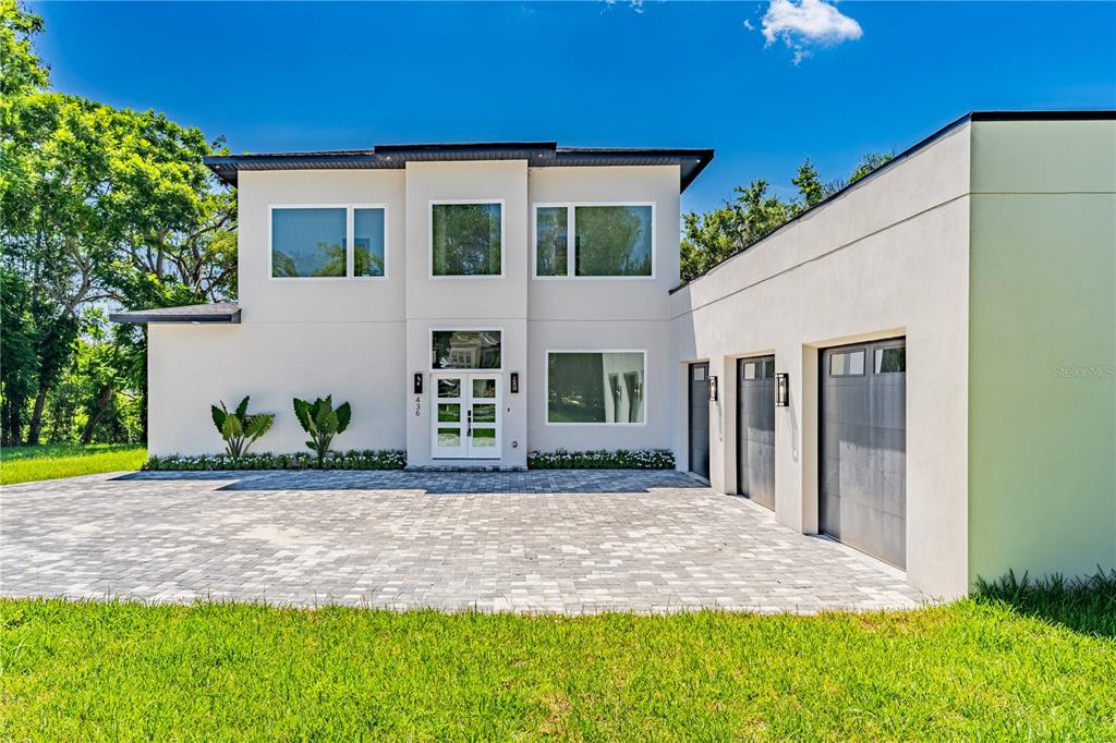 A modern two-story house with a paved driveway and a three-car garage — 436 E 7TH AVENUE, WINDERMERE, FL