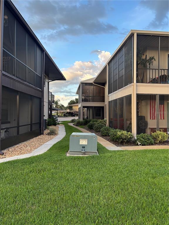A view between two multi-story apartment buildings with screened-in porches and a utility box — 1640 JUNO TRAIL UNIT 205-F, ASTOR, FL