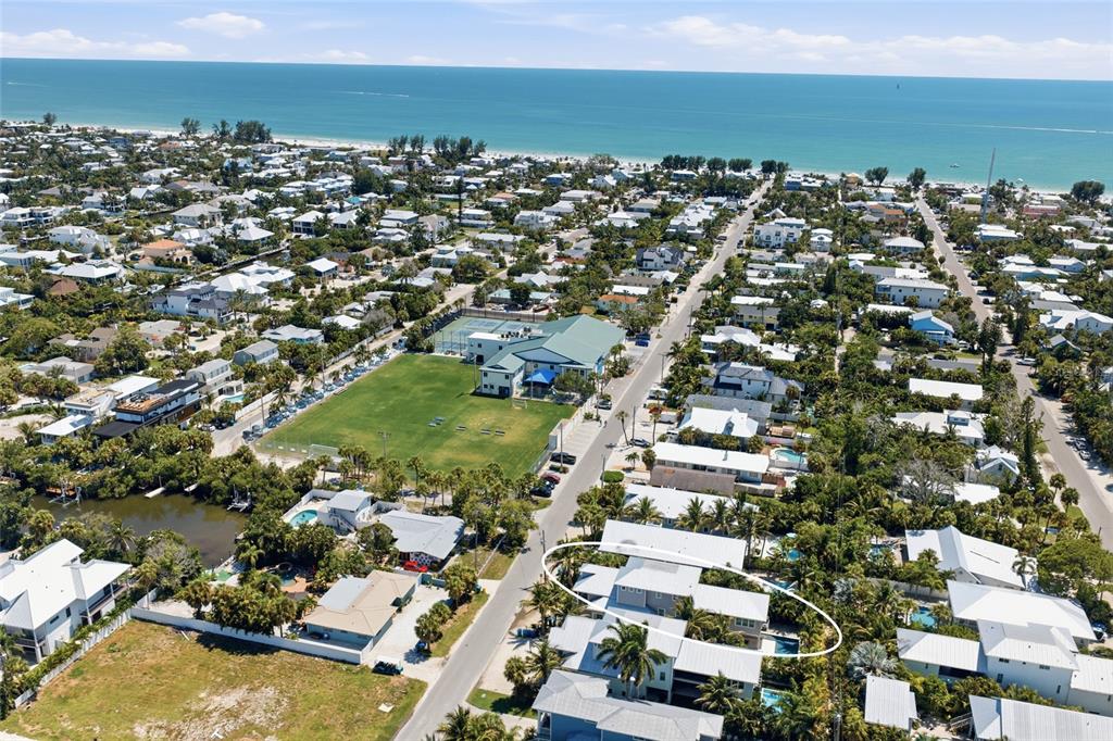 A light blue two-story house with a white balcony and two brown garage doors — 418 MAGNOLIA AVENUE, ANNA MARIA, FL
