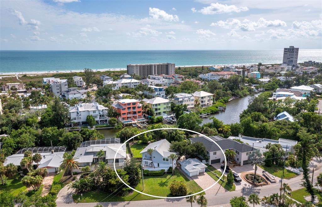 An aerial view shows a light-colored house with a detached garage in a coastal neighborhood — 430 ISLAND CIRCLE, SARASOTA, FL