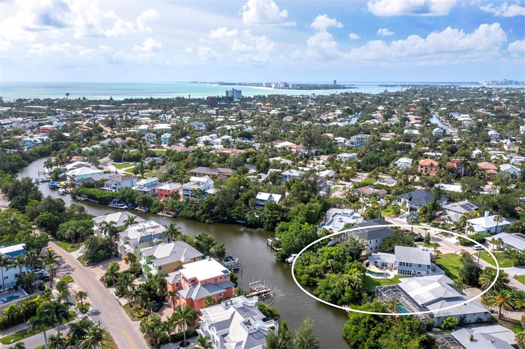 An aerial view shows a waterfront house with a pool and dock along a canal — 430 ISLAND CIRCLE, SARASOTA, FL