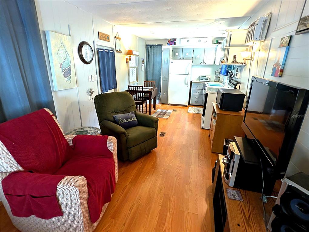 A bedroom features a wooden bed, a large dresser, a ceiling fan, and blue curtains — 7803 46TH AVENUE N UNIT 49, ST PETERSBURG, FL