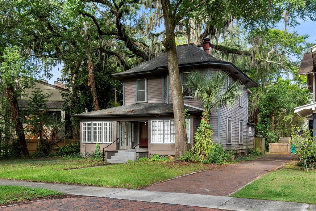 A two-story, brown wood-sided house with a brick driveway and large oak trees — 522 S OSCEOLA AVENUE, ORLANDO, FL