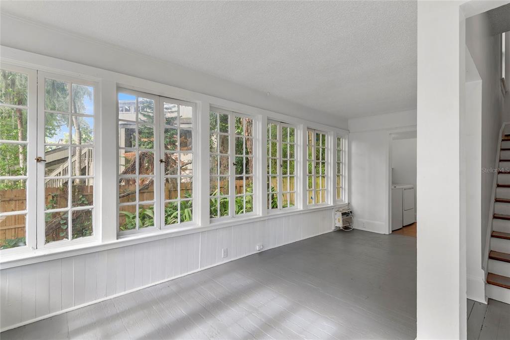 A sunroom with white walls, gray wood flooring, and a wall of multi-pane windows — 522 S OSCEOLA AVENUE, ORLANDO, FL