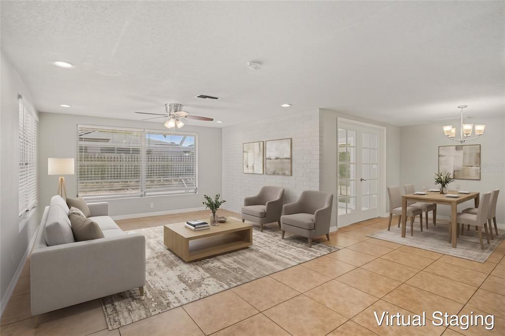 A spacious room with light-colored tile flooring, a white brick accent wall, and French doors — 8006 MIMOSA DRIVE, PORT RICHEY, FL