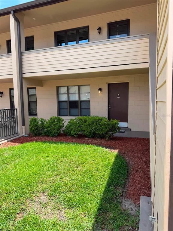 A ground-level apartment exterior features a patio with a metal railing and unit number three — 2442 NE 7TH STREET UNIT 3, OCALA, FL