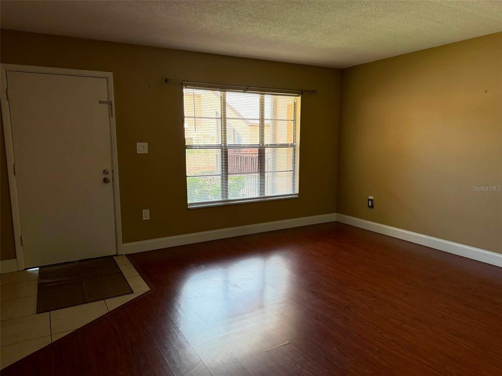 A living room features a sectional sofa, a black futon, a coffee table, and a television — 2442 NE 7TH STREET UNIT 3, OCALA, FL
