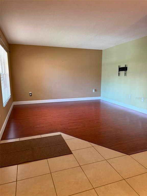 A dining area features a dark wood table with four chairs and a floor lamp — 2442 NE 7TH STREET UNIT 3, OCALA, FL