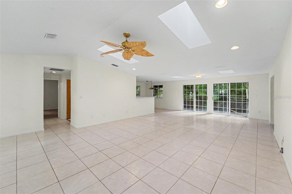 A bright, tiled living area features a vaulted ceiling with skylights and a mirrored hallway — 2057 BRENT PLACE, PALM HARBOR, FL