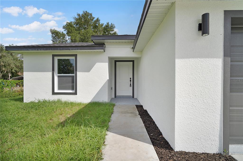 An aerial view shows a single-story house with a concrete driveway and surrounding grassy lots — 13969 SW 45TH TERRACE, OCALA, FL