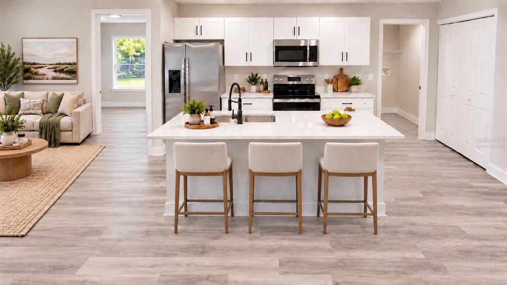 An interior view shows a hallway leading to an open-concept kitchen and living area — 13969 SW 45TH TERRACE, OCALA, FL