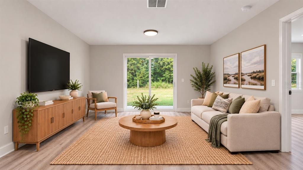 An open-concept kitchen features white cabinetry, stainless steel appliances, and light wood-look flooring — 13969 SW 45TH TERRACE, OCALA, FL