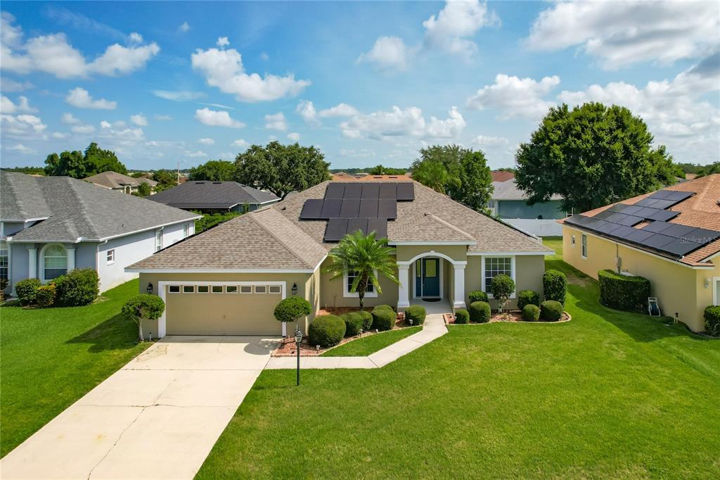 A kitchen with a marble-topped breakfast bar, stainless steel refrigerator, and wood cabinets — 301 TERRANOVA BOULEVARD, WINTER HAVEN, FL