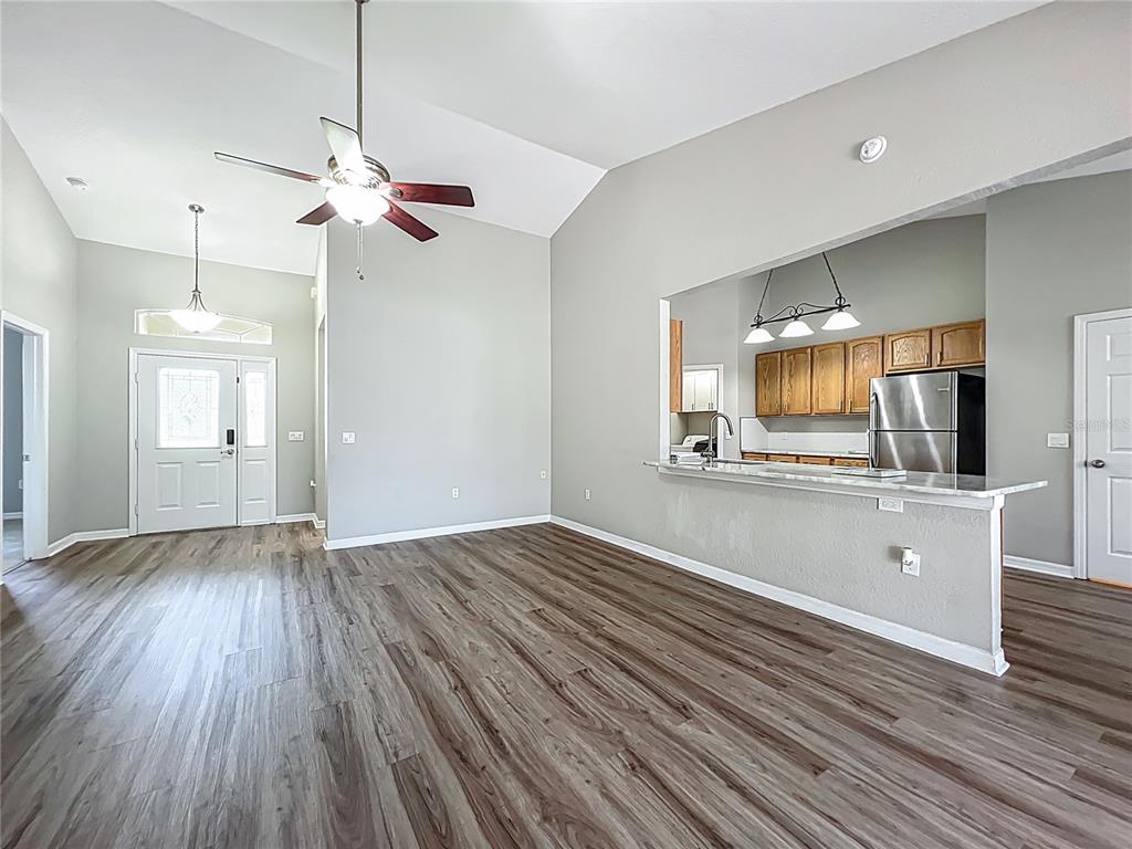 A dining room with wood-look flooring, a chandelier, and blue curtains over a window — 301 TERRANOVA BOULEVARD, WINTER HAVEN, FL